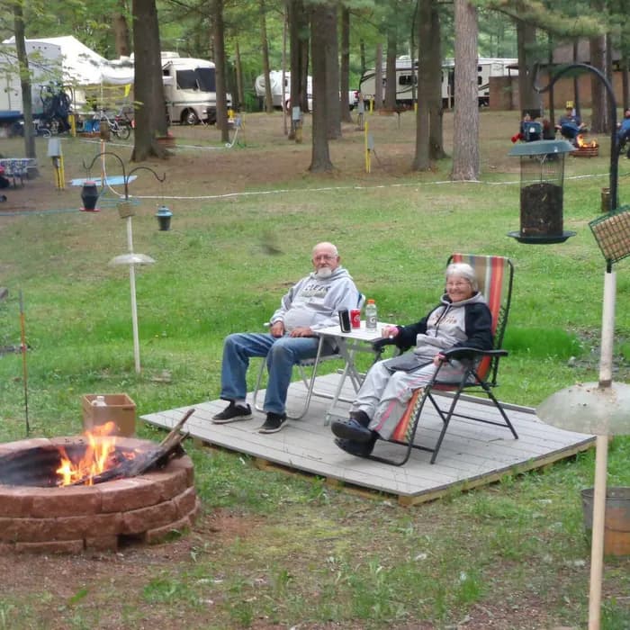 Guests relaxing on a campsite deck at West Branch Secret Campground