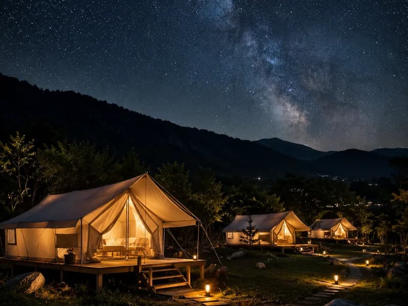 Luxury safari glamping tents lit at night under a starry sky