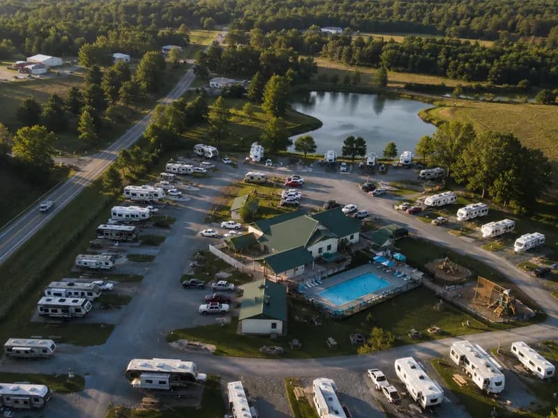 Aerial view of an RV park with pull-through sites, pool and lake