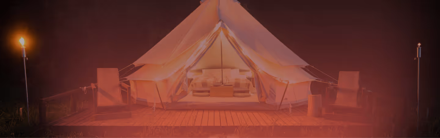 Luxury glamping tent at twilight with warm interior lighting