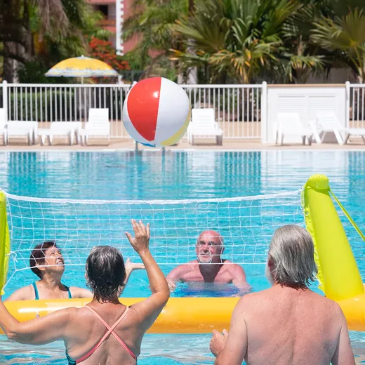 Guests playing with a beach ball in the pool